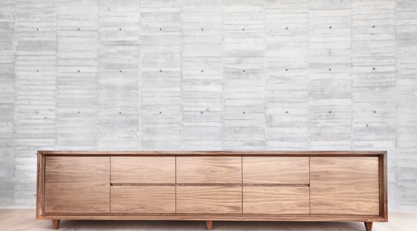 Solid American walnut credenza · hand-rubbed oil, board-formed concrete wall
